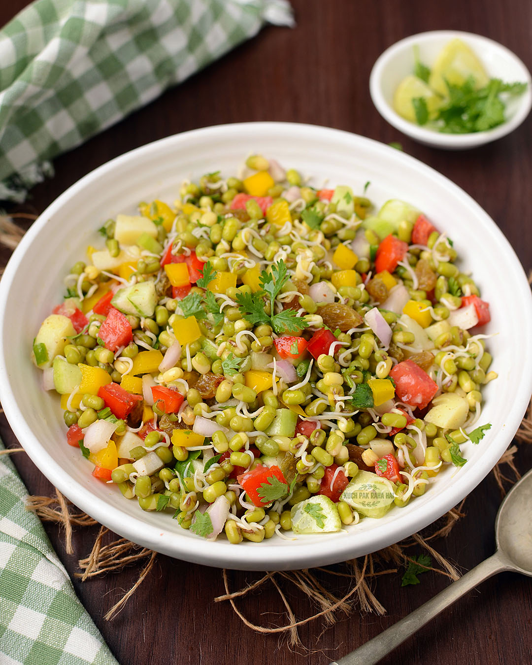 Salad with green gram sprouts, veggies and raisins.