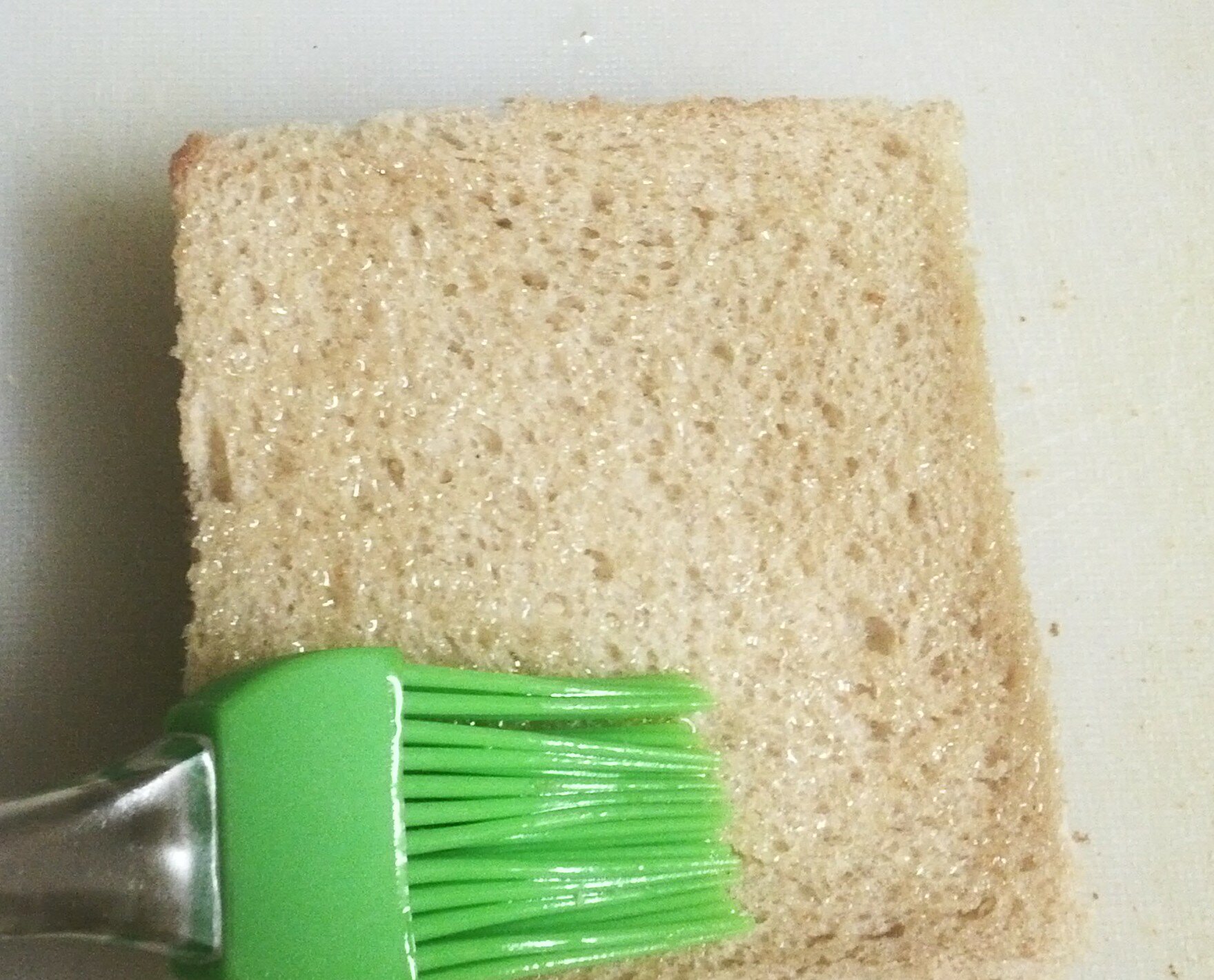 Brushing olive oil on bread slices.