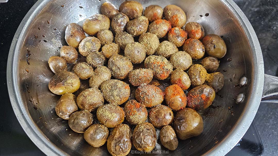 Adding spices to crispy baby potatoes.