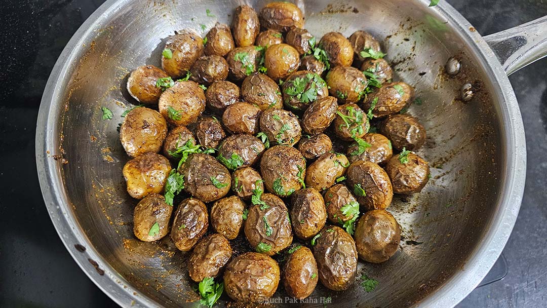 Tossing potatoes in spices and lemon juice.