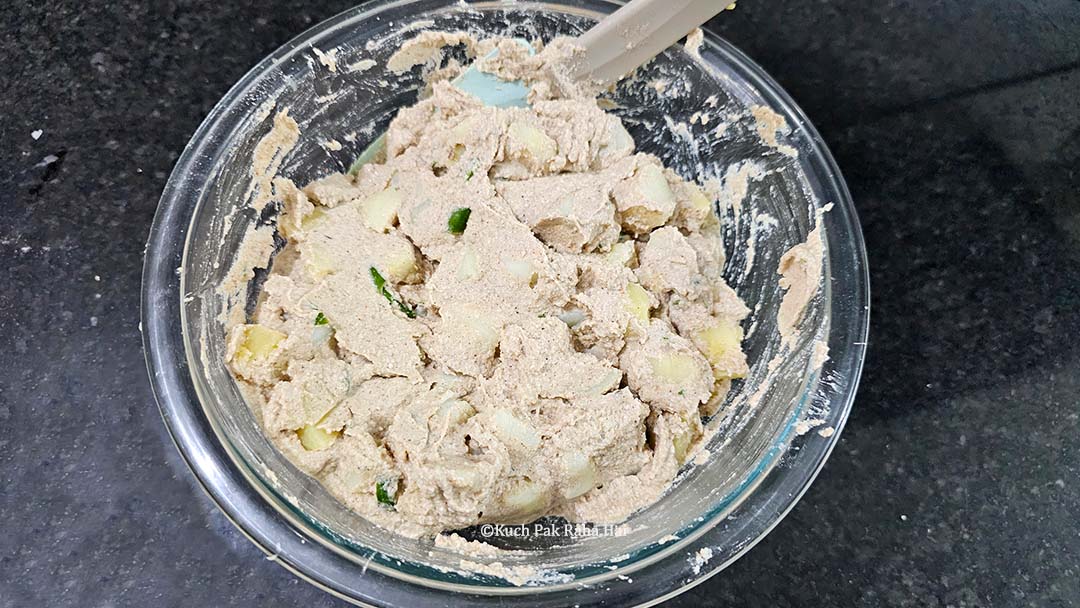 Adding potatoes to kuttu batter.