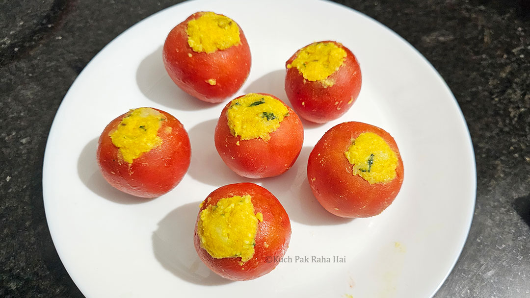 Stuffing tomatoes with potato filling.