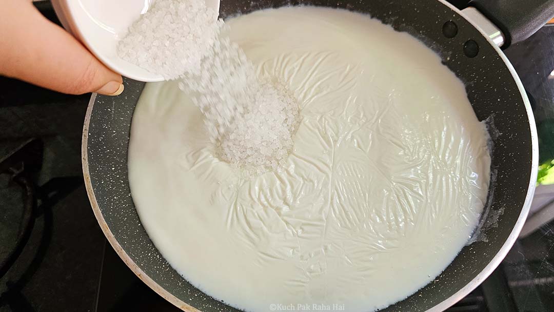 Adding sugar to hot milk.