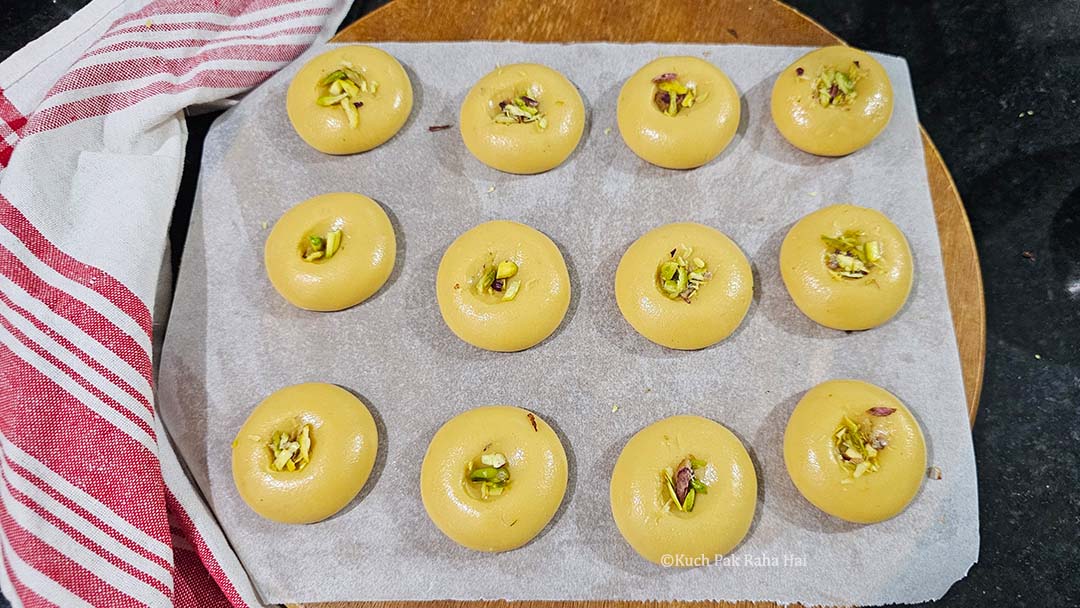 Garnishing kesar penda with chopped pistachios.