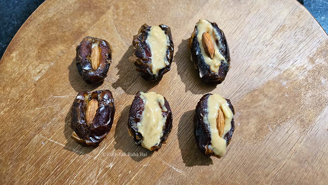 Stuffing dates with peanut butter and almonds.