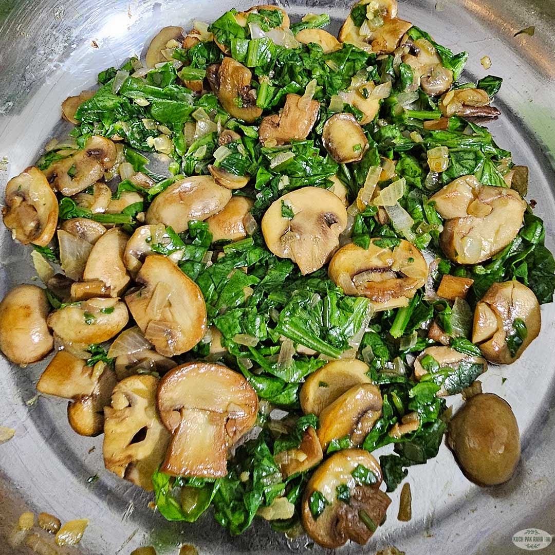 Cooking spinach till it is wilted.