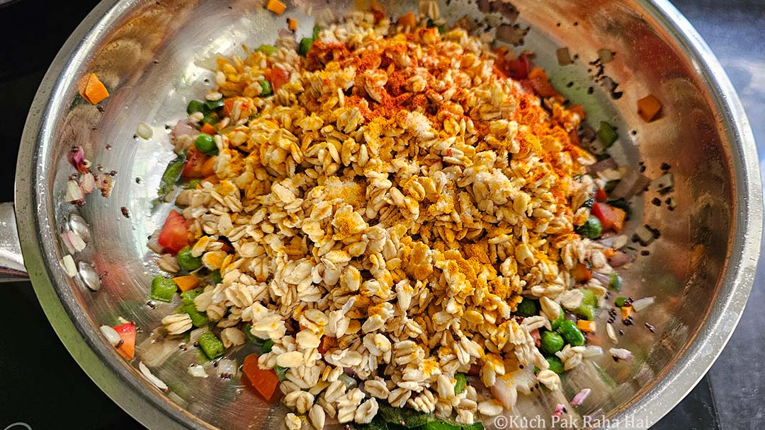 Adding soaked oats and spices to stir fried veggies.