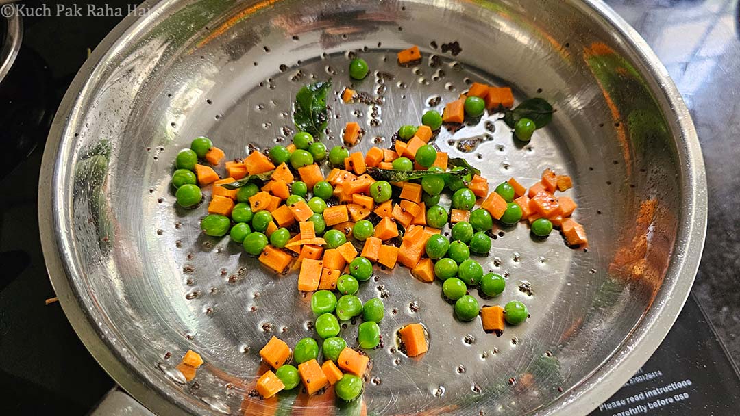 Cooking carrots and peas till tender.