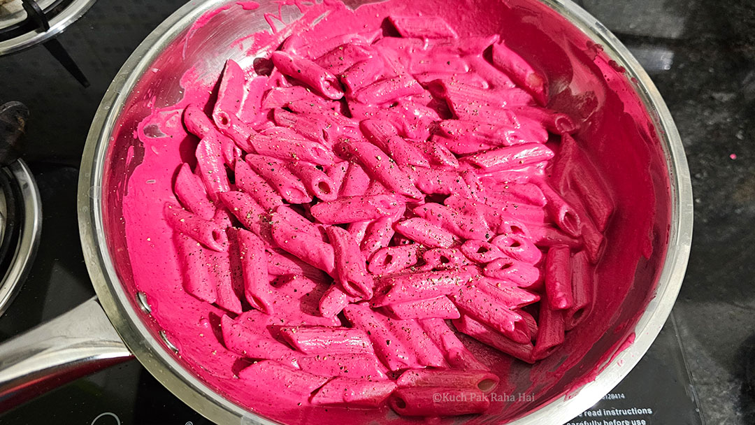 Tossing pasta in beet sauce.