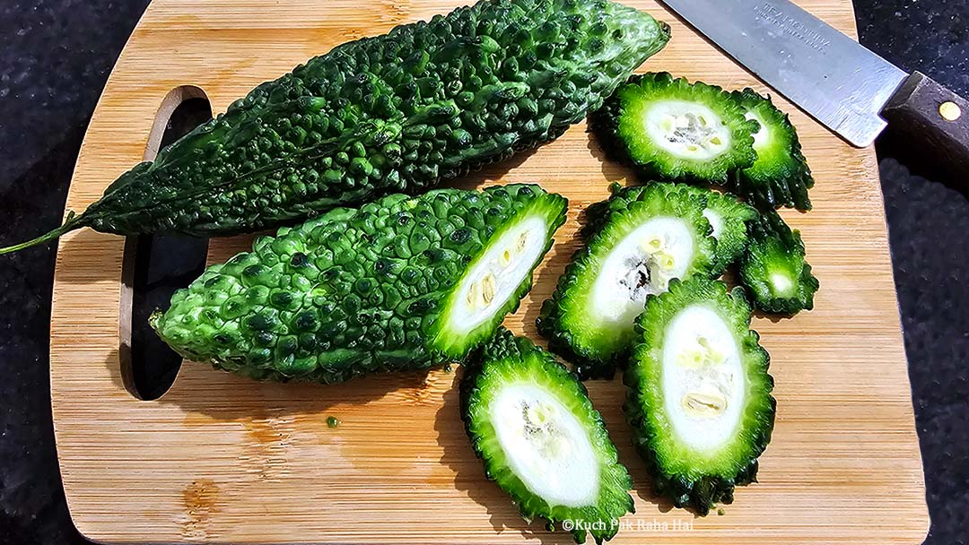 Chopping bitter melon in slices.