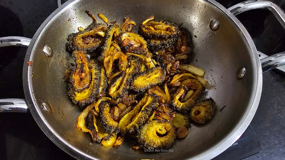 Cooking karela fry in a pan.