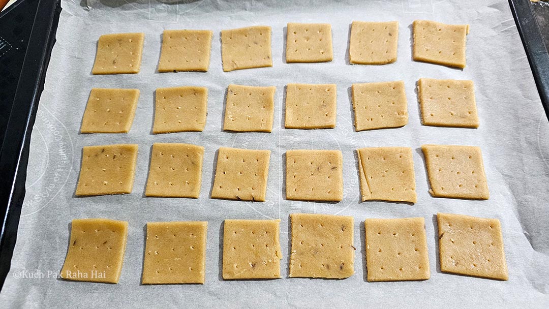 Arranging crackers on a baking tray.