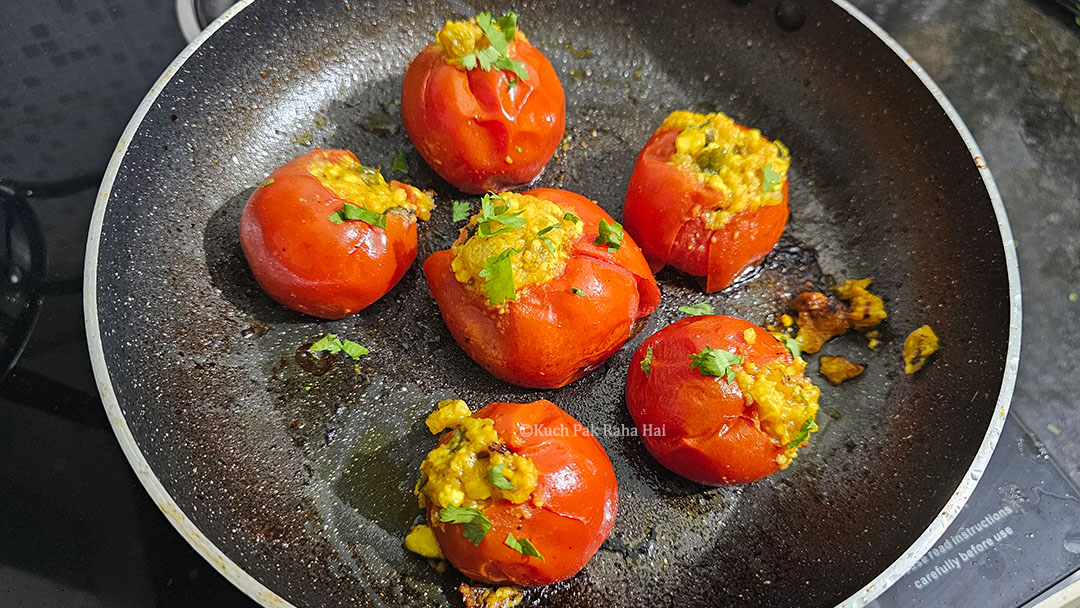 Garnishing stuffed tomatoes with cilantro.