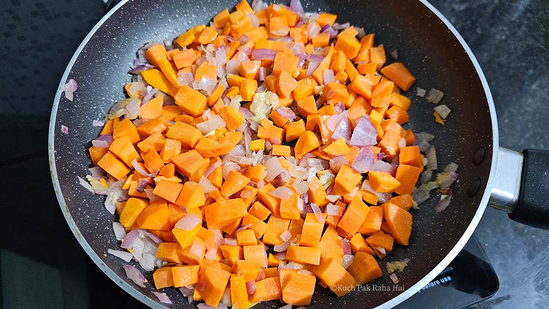 Cooking chopped carrots in pan.