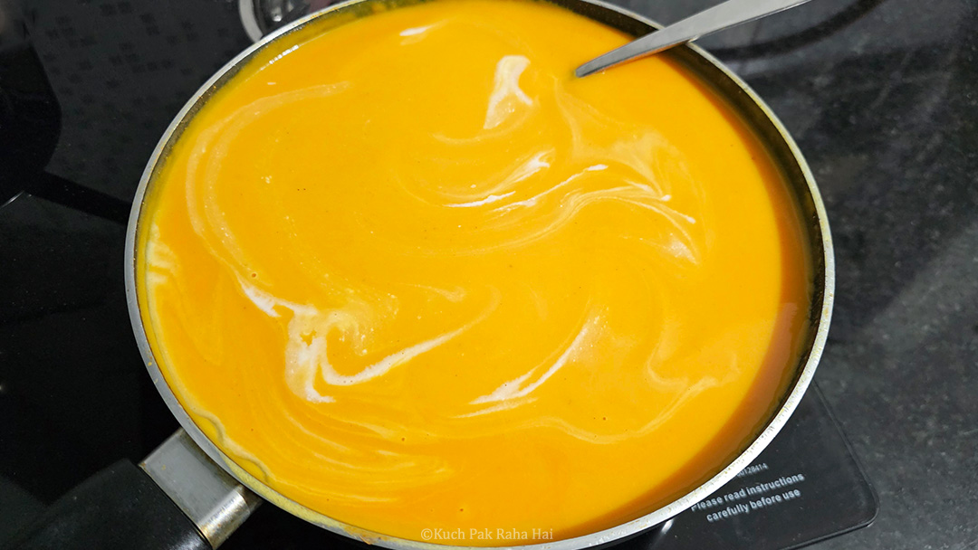 Adding coconut milk to the soup.