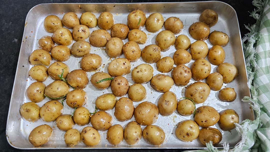 Arranging the potatoes on baking tray with cut side down.