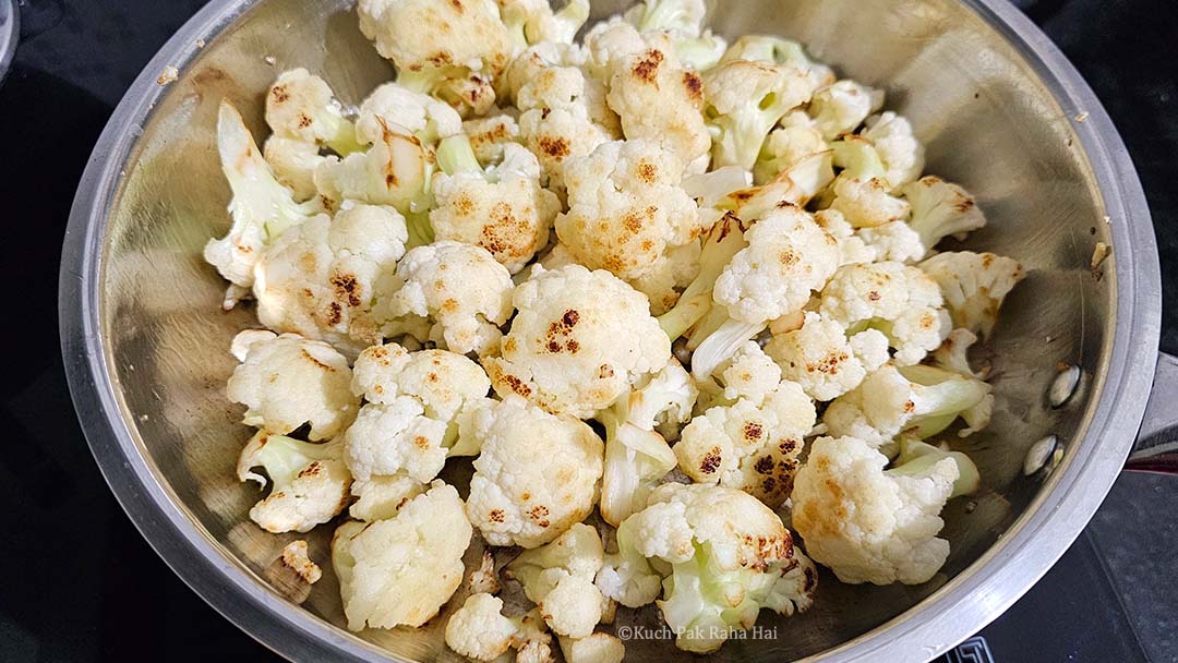 Sautéing cauliflower florets in olive oil.