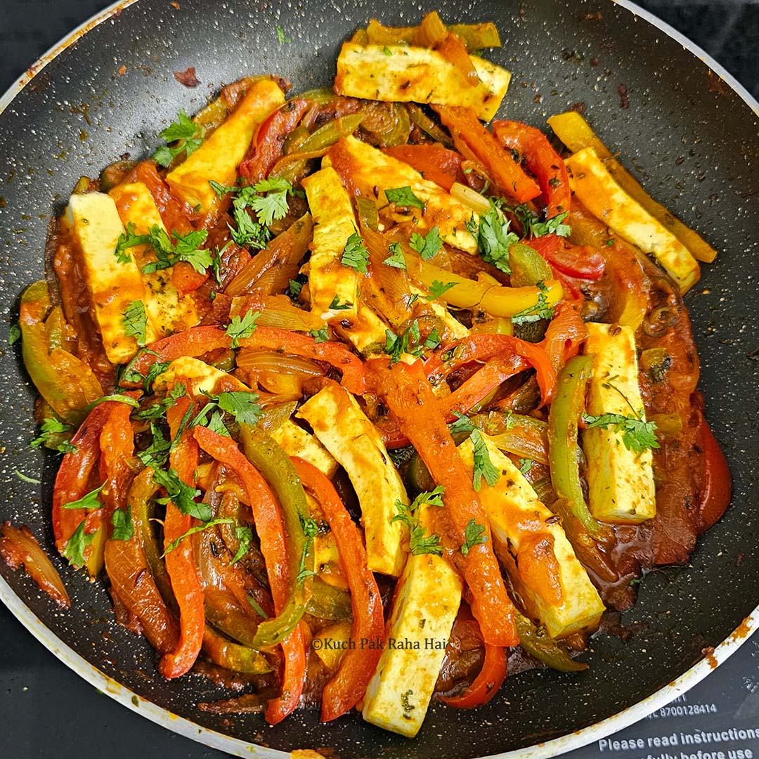 Garnishing veg jalfrezi with cilantro and lemon juice.